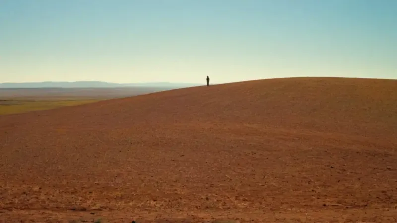 Una figura contempla el valle al atardecer