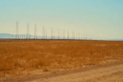 Un operario bajo una inmensa torre eléctrica