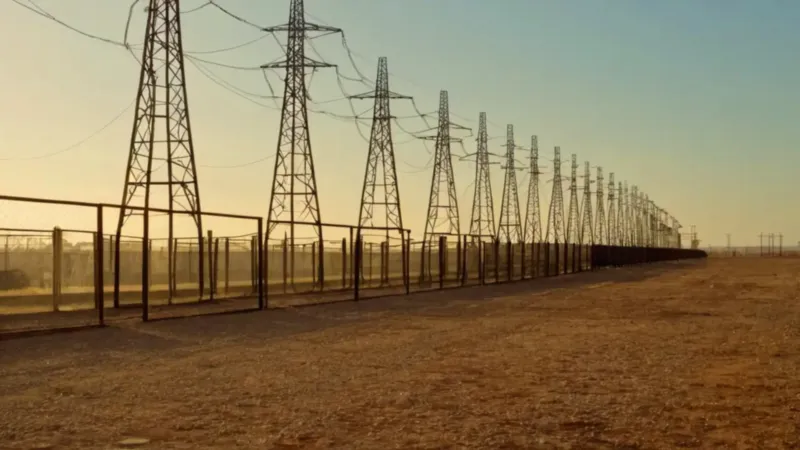 Técnico en subestación eléctrica al atardecer